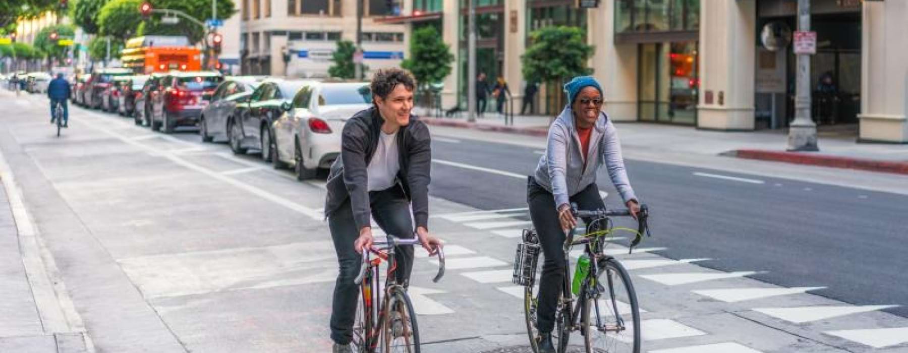 a couple of people riding bikes on a street