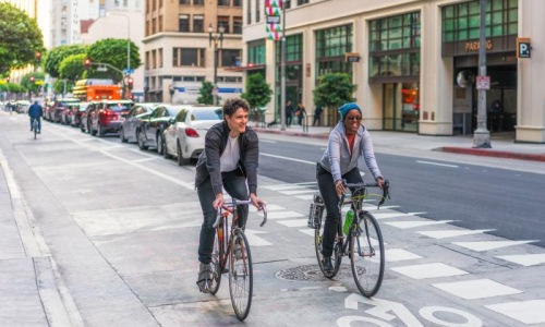 a couple of people riding bikes on a street