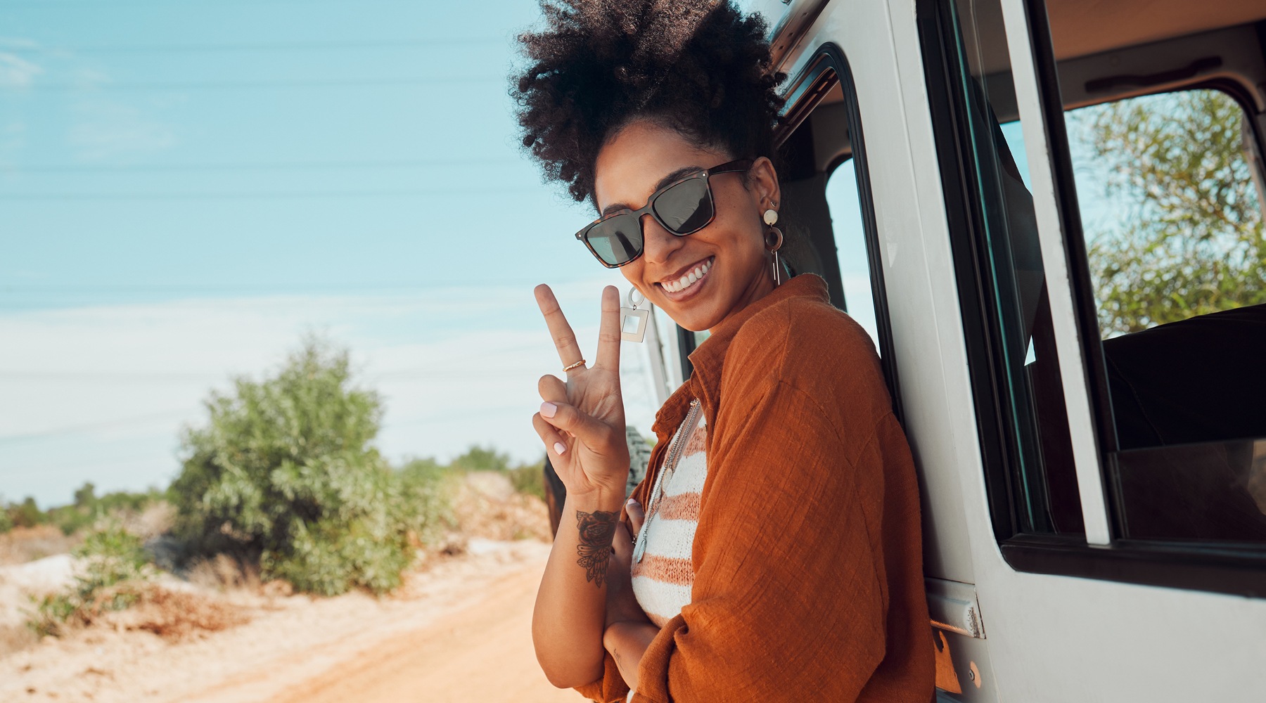 a girl standing by a vehicle by the water