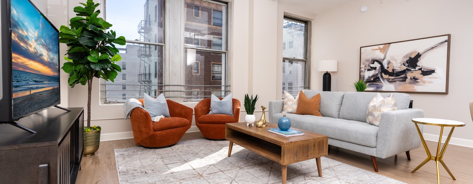 a living room with a couch, tv, chairs and a coffee table