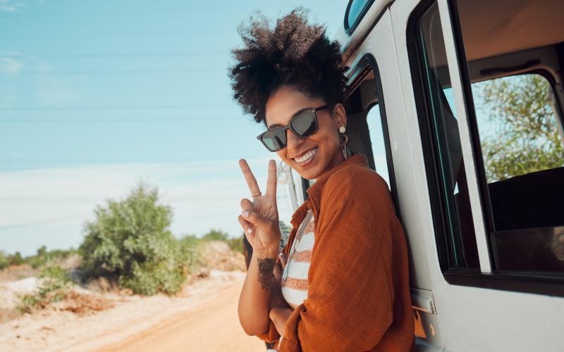 a woman standing near a vehicle by the beach